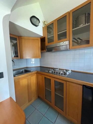 a kitchen with wooden cabinets and a sink and a stove at Divina Vita Apartments in Varenna