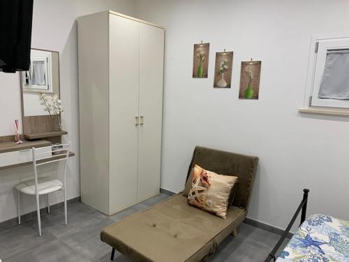 1 dormitorio con silla, 1 cama y armario en Appartamenti Mamma Marisa, en Minturno