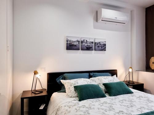 Un dormitorio con una cama con dos almohadas verdes. en Alexandre Herculano Oporto Residence I II & III, en Oporto