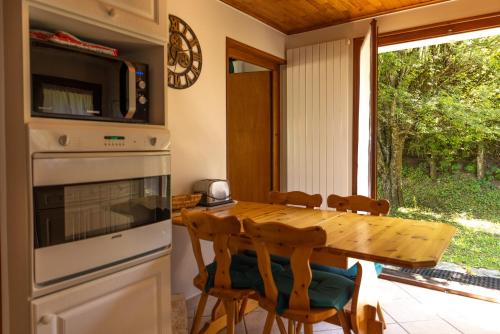 une cuisine avec une table en bois entourée de chaises. dans l'établissement Chalet Le Margouillat, aux Houches