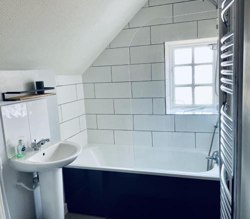 a bathroom with a sink and a bath tub at George and Dragon in Horsham