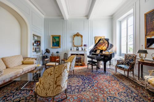 a living room with a piano and a couch at La Passerelle du Canal in Sallèles-dʼAude