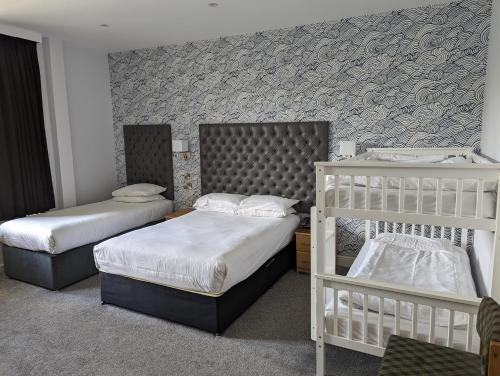 a bedroom with two bunk beds and a wall at Suncliff Hotel - OCEANA COLLECTION in Bournemouth