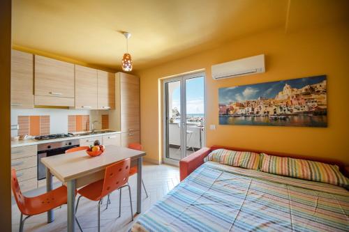 a room with a kitchen and a table and a bed at Casa Cinzia in Marina di Corricella in Procida