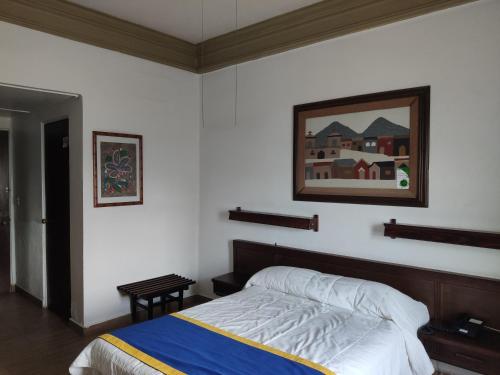- une chambre avec un lit et une photo sur le mur dans l'établissement Hotel Sierra Gorda, à Ciudad Victoria
