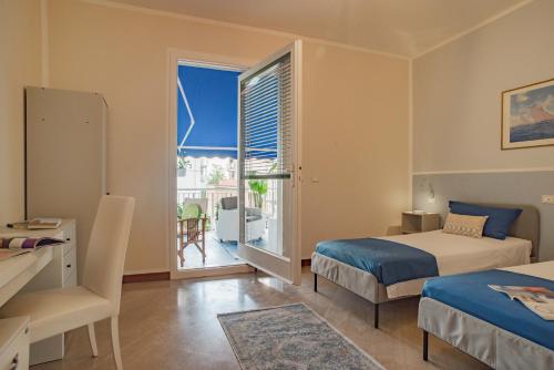 una camera da letto con due letti e una grande finestra di Home Terrace ad Alassio