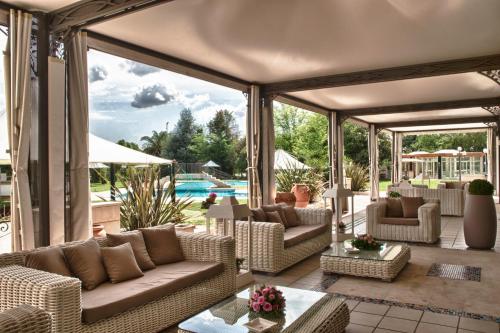 an outdoor living room with couches and a patio at Hotel Hermitage in Galatina