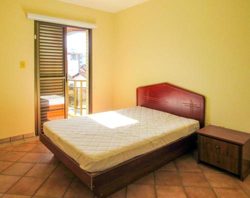 a bedroom with a large bed and a window at Apto a 600 metros da Praia Grande em Ubatuba SP in Ubatuba