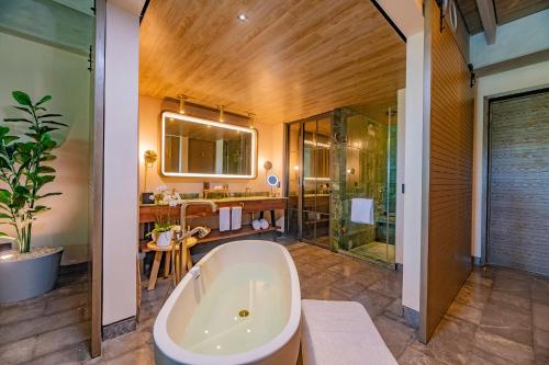 uma casa de banho com uma banheira, um chuveiro e um lavatório. em Atelier Playa Mujeres- Adults Only - All Inclusive Resort em Cancún