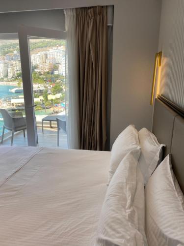 a bedroom with a bed with a view of the ocean at Demi Hotel in Sarandë