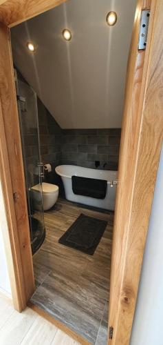 a bathroom with a bath tub and a toilet at Rucastle Apartment in Ingleton
