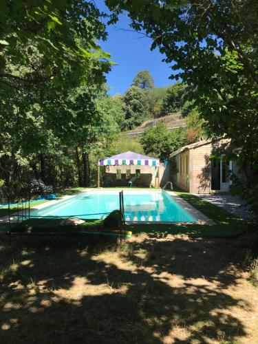 una piscina en el patio de una casa en LE PETIT REFUGE DU VAL D’EMERAUDE, en Soudorgues