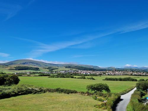 a green field with a small town in the distance at Herdwicks in Millom