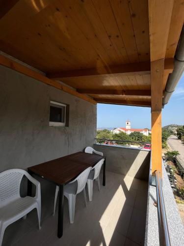 a wooden table and chairs on a balcony at Apartmani Mia in Drage