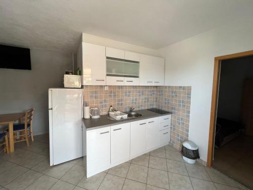 a kitchen with a sink and a white refrigerator at Apartmani Mia in Drage