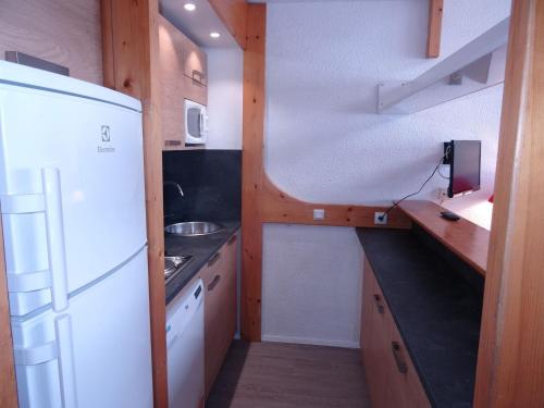 une cuisine avec un réfrigérateur blanc et un évier dans l'établissement Duplex aux Arcs 1800, 8 pers., skis aux pieds, 2 ch., animaux admis, parking, Wi-Fi - FR-1-411-383, à Arc 1800
