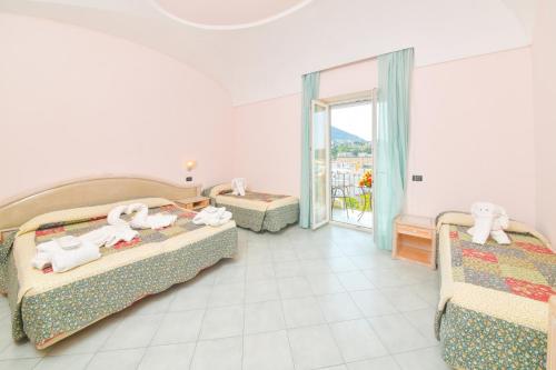 a hotel room with two beds and a balcony at Hotel Felix Terme in Ischia
