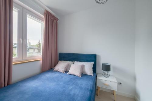 索波特的住宿－Dom & House - Apartments Mauritius，一间卧室配有一张蓝色的床和窗户