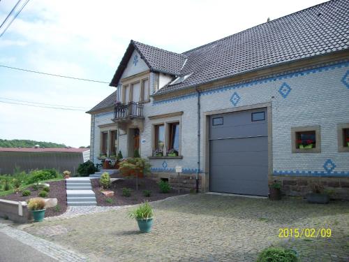 a white house with a garage at Chambres d hôtes du Stockgarten in Betting-lès-Saint-Avold