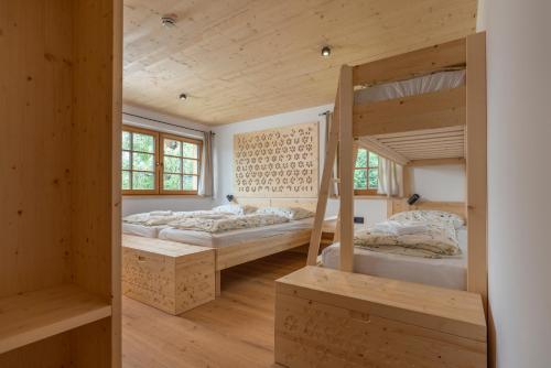 two bunk beds in a room with wooden walls at Planinska koča na Uskovnici in Srednja Vas v Bohinju