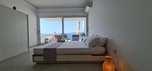a bedroom with a bed and a large window at Bona Vitae - Attico Vista Mare Castro in Castro di Lecce