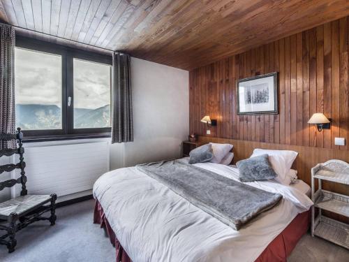 ein Schlafzimmer mit einem großen Bett und einem Fenster in der Unterkunft Appartement Courchevel 1550, 3 pièces, 6 personnes - FR-1-562-4 in Courchevel