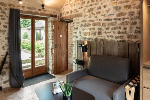 a living room with a couch and a table at Le Domaine des Prés Verts Suites & Chambres avec Jacuzzi Privatif in Jouey