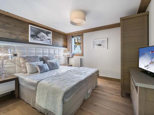 a bedroom with a large bed and a flat screen tv at Appartement Courchevel 1550, 4 pièces, 8 personnes - FR-1-562-19 in Courchevel