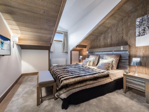 a bedroom with a large bed and a wooden wall at Appartement Courchevel 1550, 3 pièces, 4 personnes - FR-1-562-23 in Courchevel