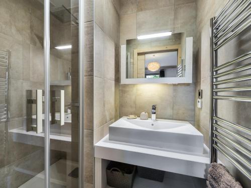 une salle de bain avec un lavabo blanc et un miroir dans l'établissement Appartement moderne au cœur de Courchevel Village, proche commerces et pistes, avec espace fitness. - FR-1-562-36, à Courchevel
