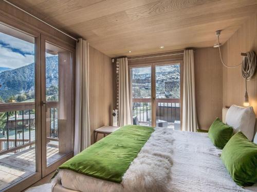 Un dormitorio con una cama grande y una ventana grande. en Chalet de luxe avec jacuzzi, hammam et salle de cinéma à Courchevel - FR-1-562-43, en Courchevel