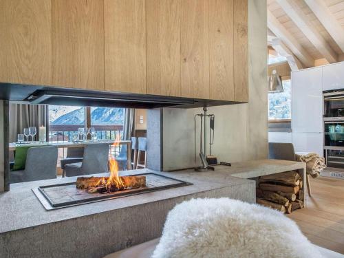- un salon avec une cheminée au milieu dans l'établissement Chalet de luxe avec jacuzzi, hammam et salle de cinéma à Courchevel - FR-1-562-43, à Courchevel