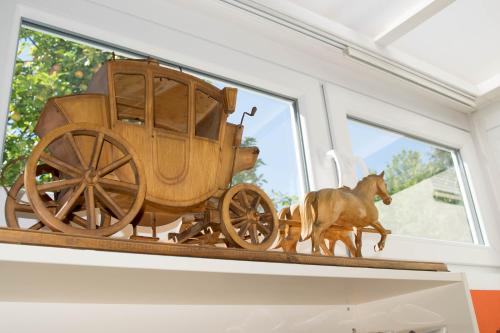 a wooden horse drawn carriage on display in a window at Hotel Postkutsche in Dortmund