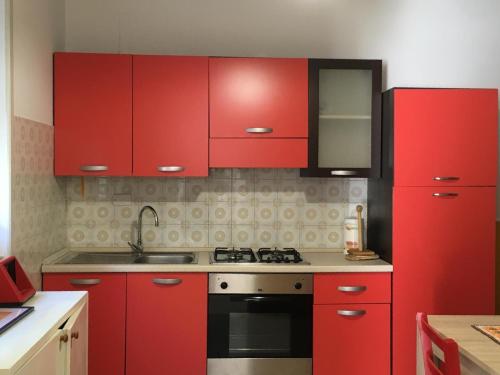 - une cuisine rouge avec des placards rouges et une cuisinière dans l'établissement Casa Ada, à Leuca