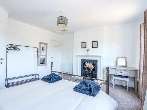 a bedroom with a bed with blue towels on it at Lily Cottage in Downham Market