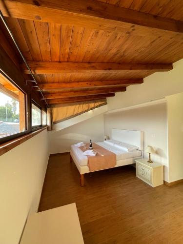 a bedroom with a large bed and a wooden ceiling at Villetta Climene Apartment in Giardini Naxos