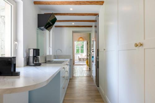 une cuisine avec des armoires blanches et un comptoir dans l'établissement L'élégant de Stanislas - T3 lumineux à Nancy, à Nancy