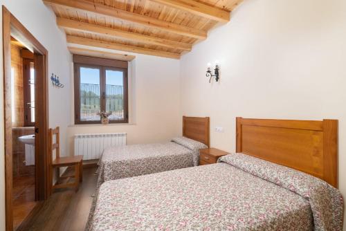 a bedroom with two beds and a window at Casa Rural Solapeña in Pallide