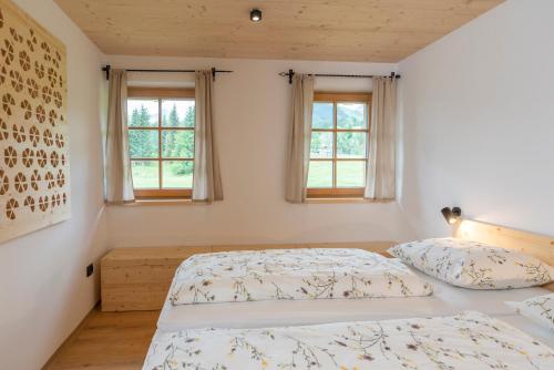 a bedroom with two beds and two windows at Planinska koča na Uskovnici in Srednja Vas v Bohinju