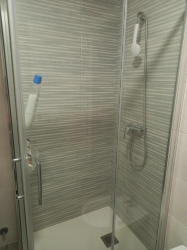 a shower stall with a glass door in a bathroom at Mi casa in Plasencia