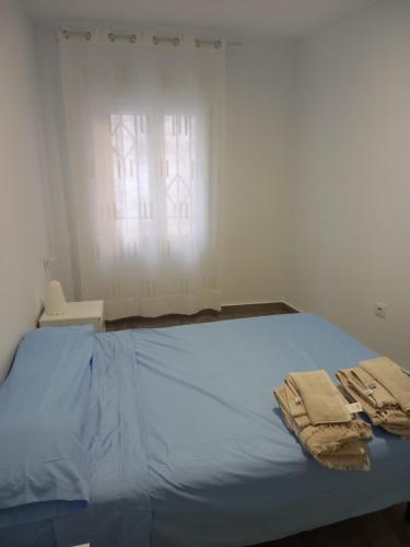a bedroom with a bed with two towels on it at Mi casa in Plasencia