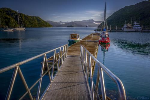 a dock with boats on a body of water at High Street Living Motel in Picton