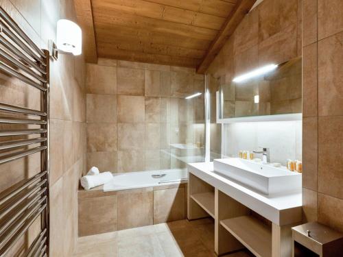 a bathroom with a white sink and a tub at Appartement moderne proche pistes, 4 chambres, parking, WiFi - FR-1-562-58 in Courchevel