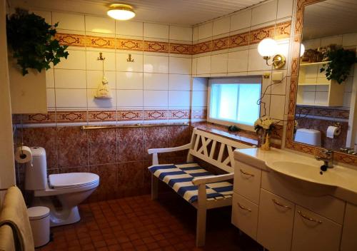 a bathroom with a toilet and a sink and a mirror at Lovely Mint Garden Studio in Vantaa
