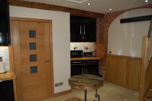 a kitchen with black cabinets and a wooden door at The Hyde Dovecote Kinver in Stourbridge