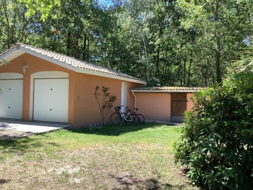 a house with a bike parked in front of it at La Morandiere in Grayan-et-lʼHôpital