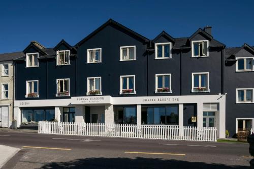 a white and blue building with a white and blue roof at Schull Harbour Hotel & Leisure Centre in Schull