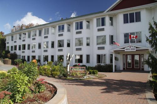 a large white building with a courtyard at Auberge Gisele's Inn in Baddeck