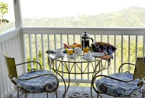 a breakfast table on a balcony with two chairs at Strawberry Hill in Newcastle
