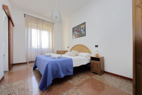 ローマにあるSilvano's Home In Romeのベッドルーム1室(青い毛布付きのベッド1台付)